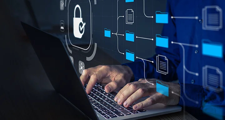 ロックとフォルダのグラフィックが表示されたノートパソコンを使用している人物