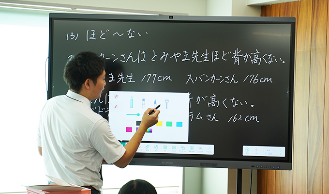 電子黒板のペンの種類を変更する先生。